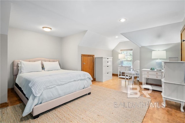 bedroom featuring light hardwood / wood-style floors and vaulted ceiling