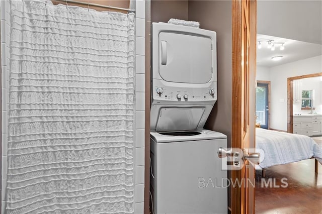 laundry room featuring stacked washer / dryer and sink