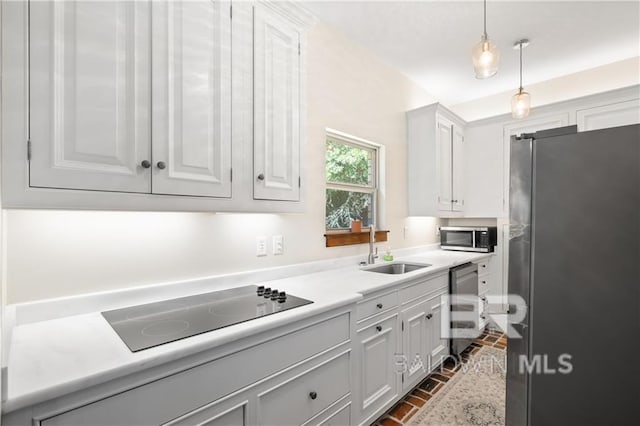 kitchen featuring white cabinets, sink, decorative light fixtures, and appliances with stainless steel finishes