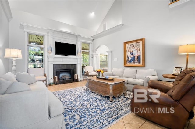 tiled living room featuring a fireplace and high vaulted ceiling