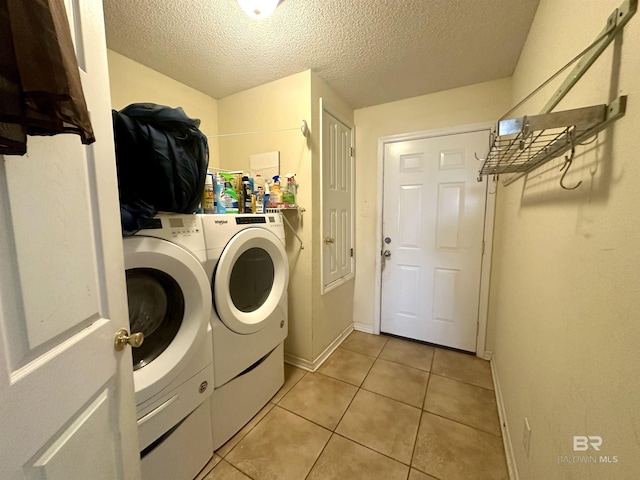 laundry area featuring laundry area, baseboards, independent washer and dryer, a textured ceiling, and light tile patterned flooring