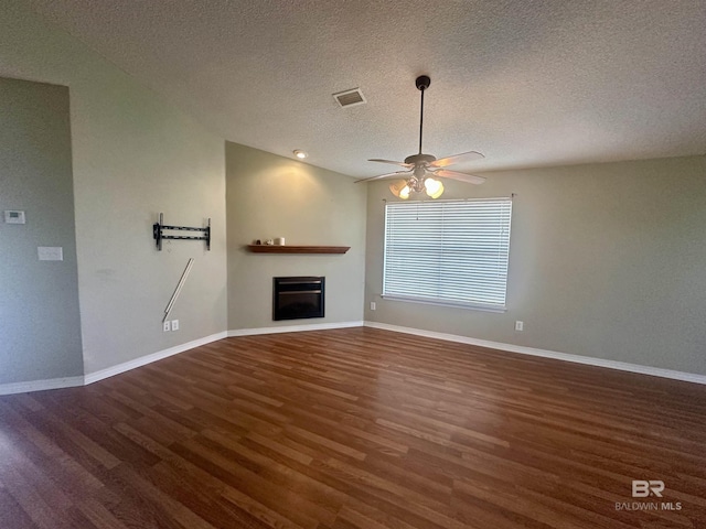 unfurnished living room with ceiling fan, a textured ceiling, wood finished floors, baseboards, and a glass covered fireplace