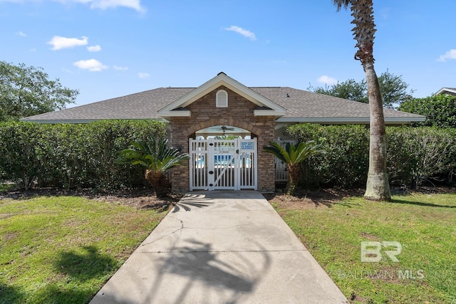 450 Park Ave Unit 112, Foley, AL 36535 - view of front of house with roof with shingles, a front lawn, and stone siding