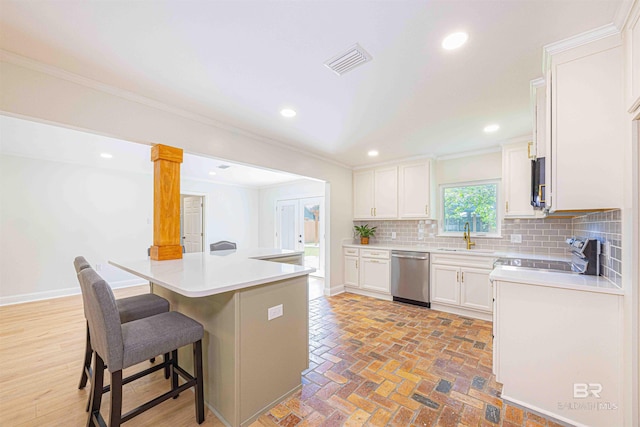 362 Azalea St, Fairhope, AL 36532 - kitchen featuring appliances with stainless steel finishes, ornamental molding, a kitchen bar, decorative backsplash, and white cabinetry
