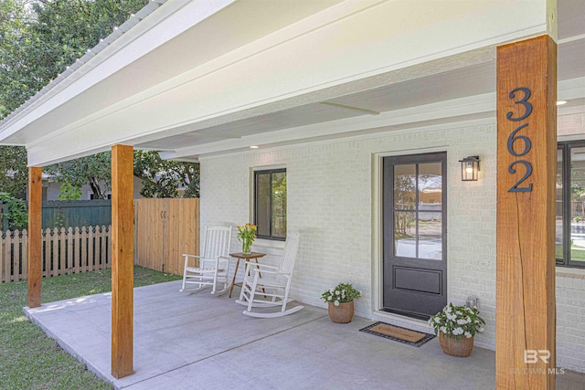 362 Azalea St, Fairhope, AL 36532 - doorway to property featuring fence, brick siding, and a patio area