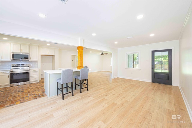 362 Azalea St, Fairhope, AL 36532 - kitchen featuring stainless steel appliances, open floor plan, light wood finished floors, a breakfast bar area, and light countertops