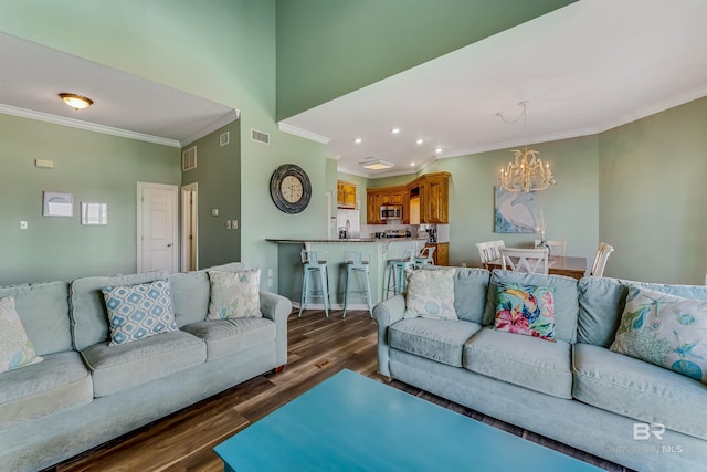 living room with a notable chandelier, dark hardwood / wood-style floors, and ornamental molding