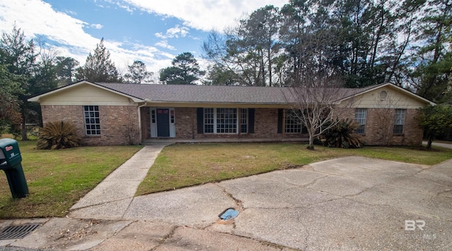 single story home with brick siding and a front yard