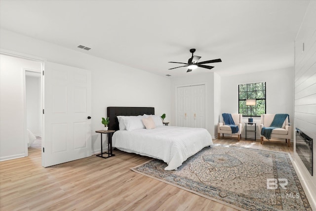 bedroom with a ceiling fan, visible vents, light wood-style flooring, and a closet