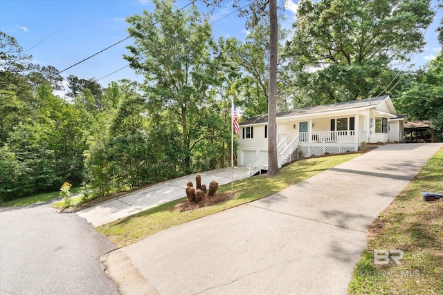 view of front of house featuring covered porch, driveway, and a garage