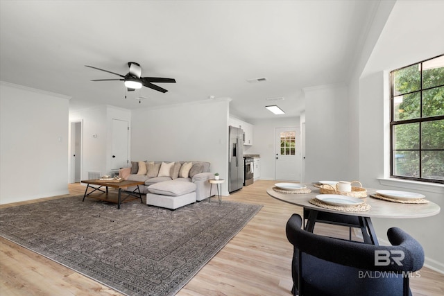 living room with light wood-style floors, a ceiling fan, baseboards, and visible vents