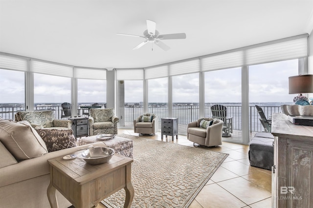 sunroom featuring a water view and ceiling fan