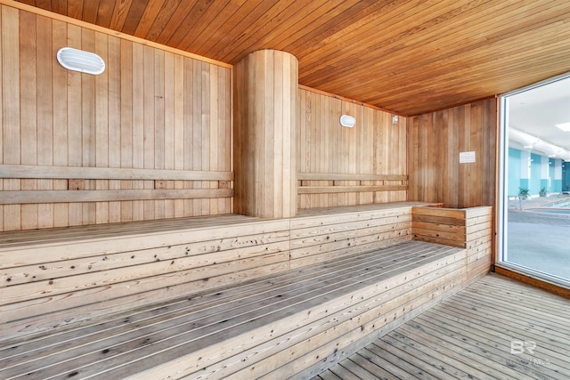 view of sauna / steam room featuring wood walls, wood-type flooring, and wooden ceiling