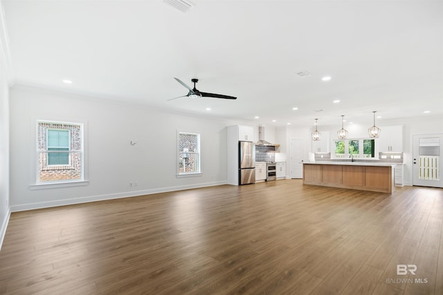 unfurnished living room with ceiling fan, plenty of natural light, light hardwood / wood-style flooring, and sink