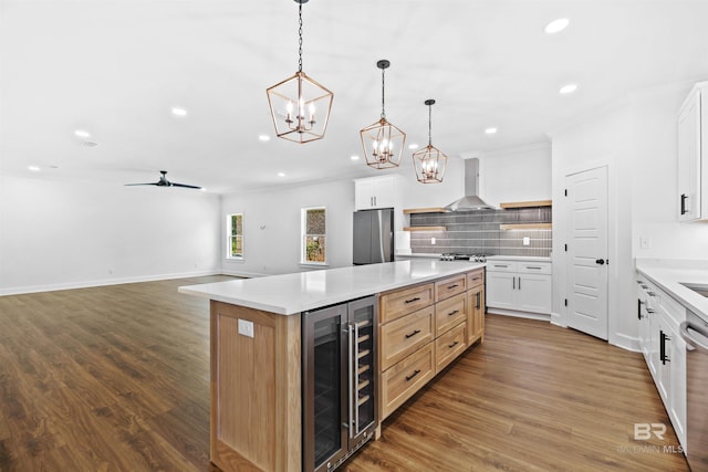 kitchen featuring beverage cooler, white cabinets, a large island, and decorative light fixtures