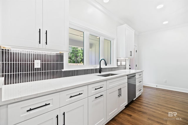 kitchen featuring white cabinetry, tasteful backsplash, light stone countertops, stainless steel dishwasher, and sink