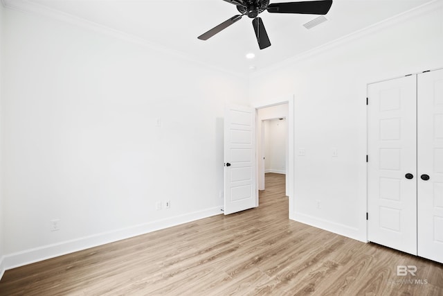 unfurnished bedroom with ceiling fan, crown molding, light hardwood / wood-style floors, and a closet