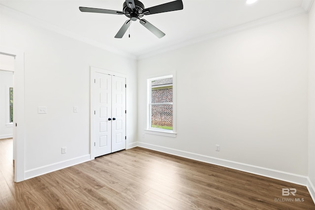 unfurnished bedroom featuring ceiling fan, light hardwood / wood-style floors, a closet, and crown molding