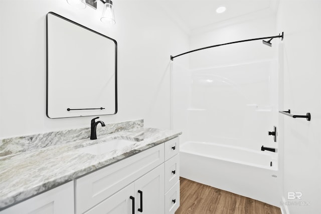 bathroom with shower / bath combination, crown molding, wood-type flooring, and vanity