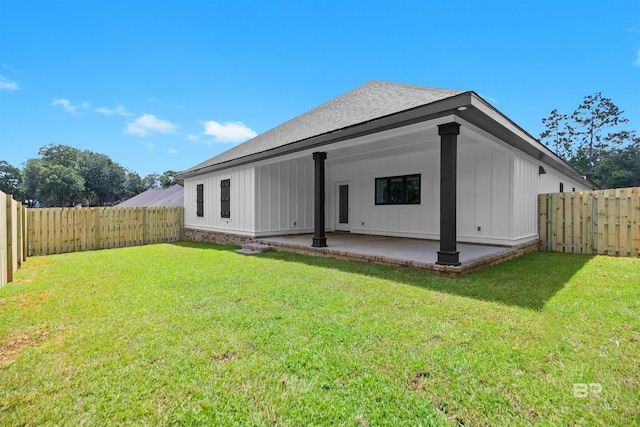 back of house with a yard and a patio