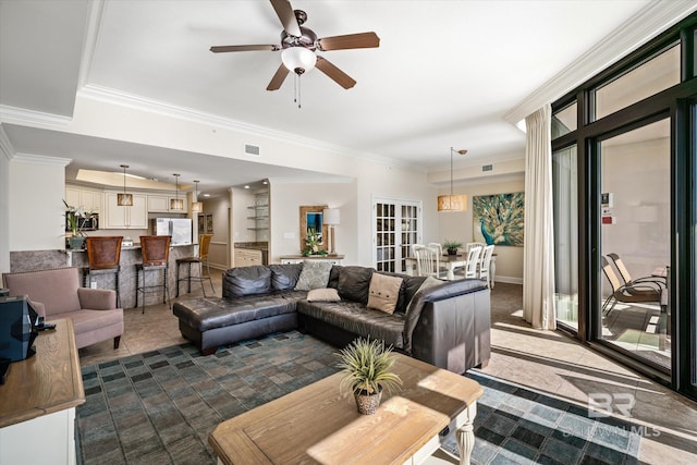 living room featuring tile patterned flooring, ceiling fan, and ornamental molding