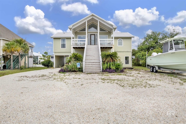 coastal home featuring stairway, a carport, metal roof, and driveway