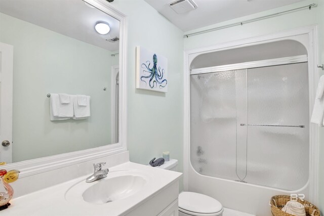 full bathroom featuring combined bath / shower with glass door, toilet, and vanity