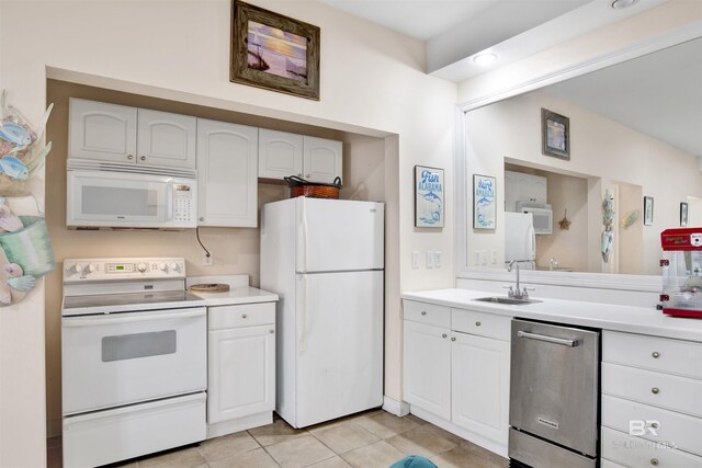 kitchen featuring light tile patterned floors, white cabinetry, white appliances, and sink