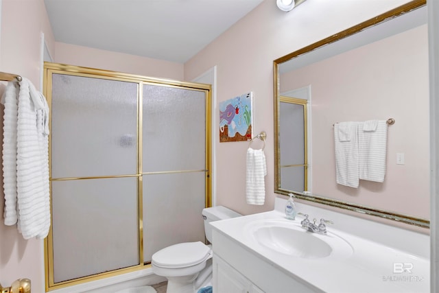 bathroom featuring a shower with shower door, vanity, and toilet