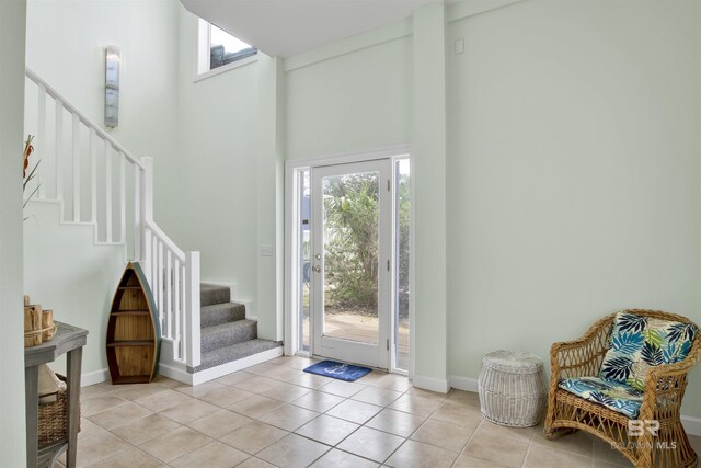 foyer featuring light tile patterned flooring and a high ceiling