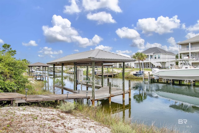 view of dock with boat lift, a residential view, and a water view