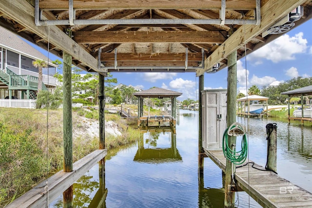 view of dock with boat lift and a water view