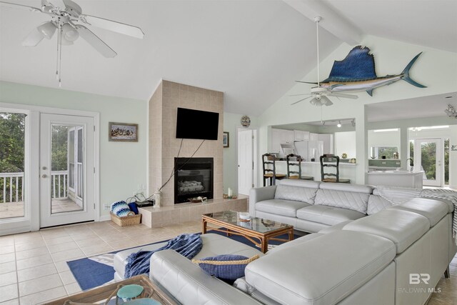 tiled living room with french doors, ceiling fan, tile walls, a fireplace, and lofted ceiling with beams