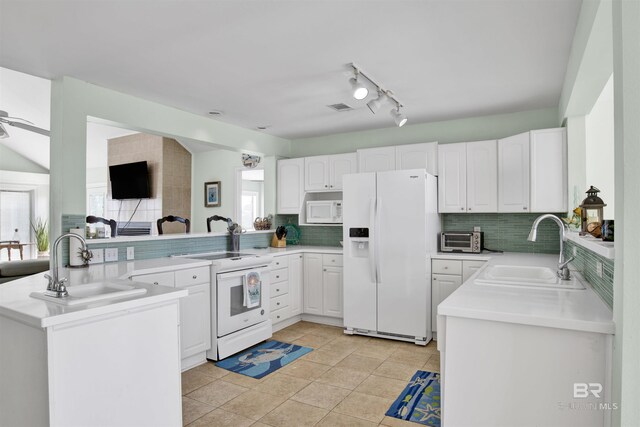 kitchen with tasteful backsplash, white appliances, sink, kitchen peninsula, and light tile patterned floors