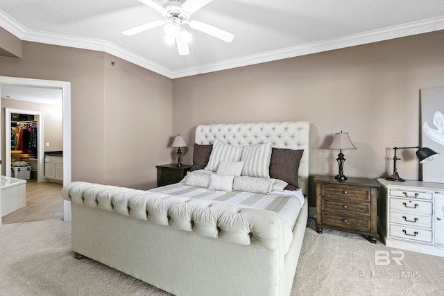 bedroom with a closet, ceiling fan, light carpet, a walk in closet, and ornamental molding