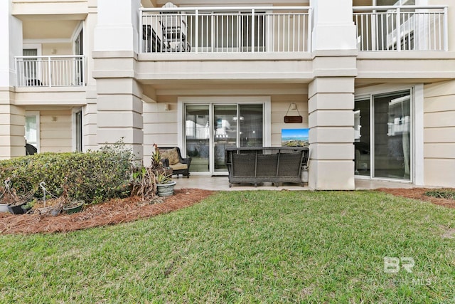 view of exterior entry with a lawn and outdoor lounge area