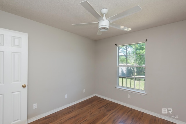 spare room featuring dark wood-style floors, baseboards, a textured ceiling, and ceiling fan