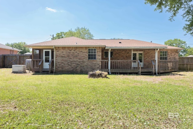 back of house featuring a yard, brick siding, and fence