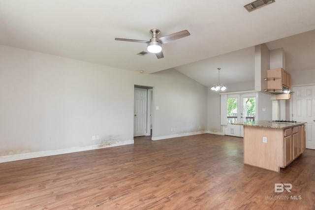 kitchen with visible vents, open floor plan, vaulted ceiling, and light brown cabinets