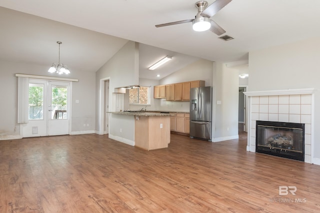 kitchen featuring open floor plan, visible vents, stainless steel fridge, and vaulted ceiling