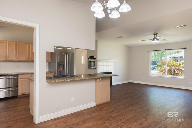kitchen with visible vents, baseboards, light brown cabinetry, dark wood-style floors, and stainless steel appliances