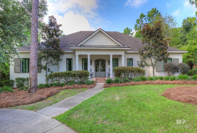 neoclassical home with french doors, a porch, a front yard, and a shingled roof