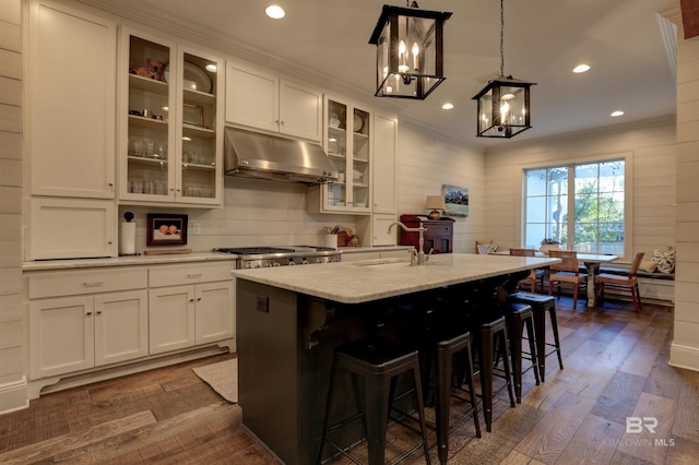 kitchen featuring crown molding, white cabinets, dark wood-style floors, and under cabinet range hood