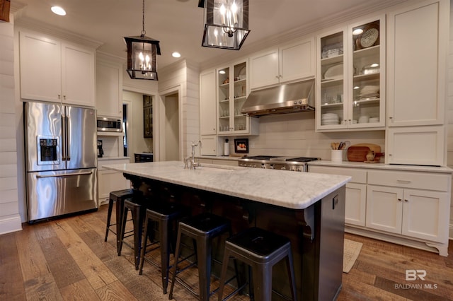 kitchen with under cabinet range hood, white cabinetry, stainless steel appliances, and a sink