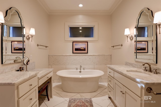 bathroom featuring a wainscoted wall, vanity, a freestanding bath, and crown molding