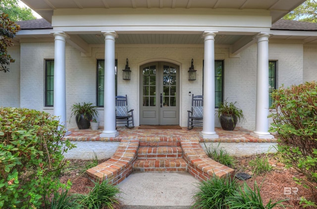 property entrance with french doors, covered porch, and roof with shingles