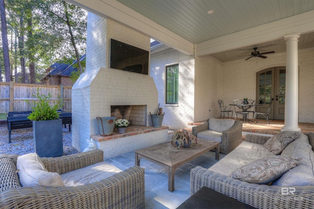 view of patio with an outdoor living space with a fireplace, french doors, a ceiling fan, and fence