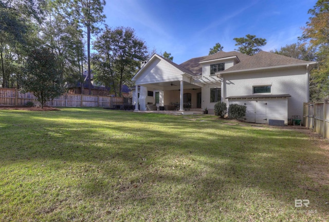 back of property featuring a yard, a fenced backyard, a patio area, and a ceiling fan