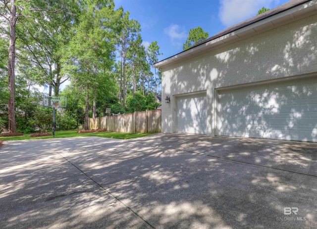 garage with driveway and fence