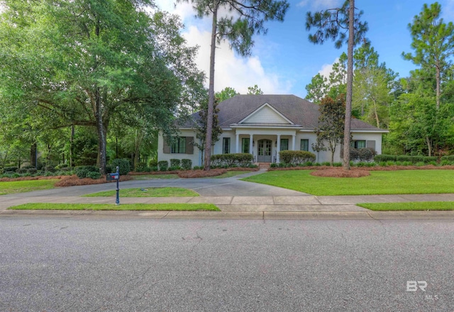 neoclassical home with aphalt driveway and a front yard